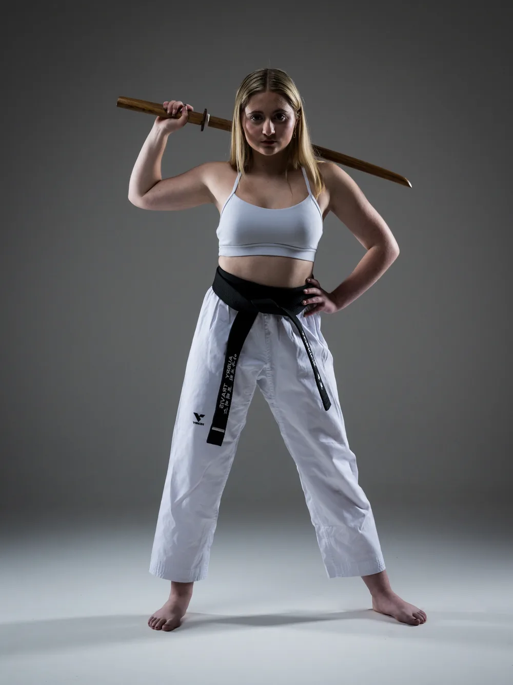 Aubry Travis in a taekwondo uniform holding a bokken, a wooden sword